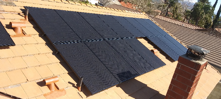 Fifteen solar panels on single-family home with brick chimney.