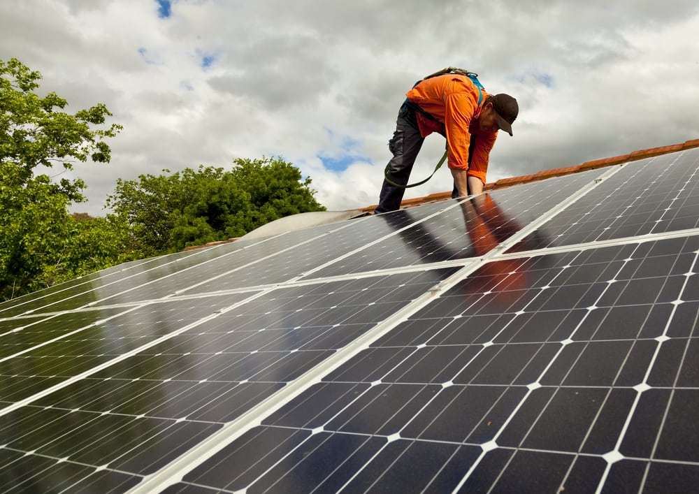 Worker installing solar panels on a rooftop